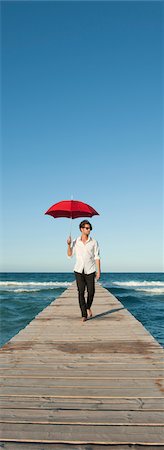 simsearch:632-05817130,k - Junger Mann zu Fuß auf Pier mit Regenschirm Stockbilder - Premium RF Lizenzfrei, Bildnummer: 632-05759947