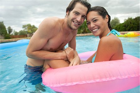 pool woman inflatable tube - Couple together in swimming pool, portrait Foto de stock - Sin royalties Premium, Código: 632-05759976