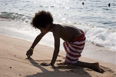 Boy playing in sand at the beach Foto de stock - Sin royalties Premium, Código: 632-05760089