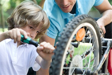 dad and son on bike - Boy repairing bicycle with father's help Stock Photo - Premium Royalty-Free, Code: 632-05760109