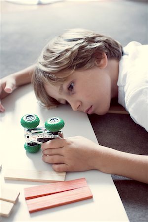 Boy playing with toy car Foto de stock - Sin royalties Premium, Código: 632-05760182