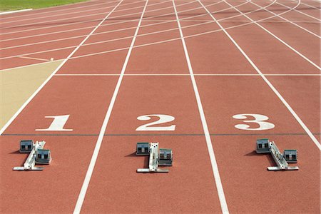 fila - Starting blocks at starting line on running track Foto de stock - Sin royalties Premium, Código: 632-05760353