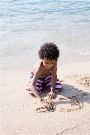 Boy writing in sand at the beach Stock Photo - Premium Royalty-Free, Code: 632-05760378