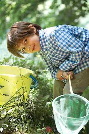 simsearch:633-05401634,k - Boy leaning over bucket with fishing net in hands Fotografie stock - Premium Royalty-Free, Codice: 632-05760444