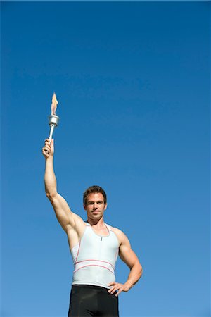 simsearch:632-05759509,k - Male athlete holding up torch Stock Photo - Premium Royalty-Free, Code: 632-05760495