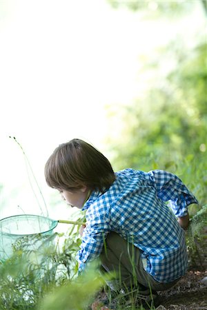 Boy catching tadpoles at water's edge Fotografie stock - Premium Royalty-Free, Codice: 632-05760527