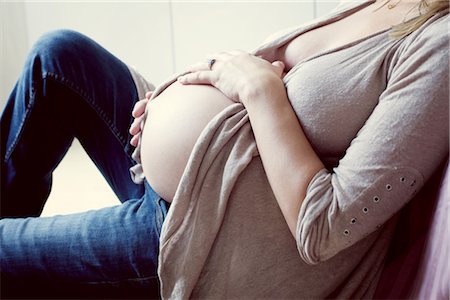Pregnant woman caressing abdomen, mid section Stock Photo - Premium Royalty-Free, Code: 632-05760532