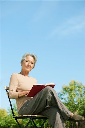 Senior woman sitting outdoors with book, portrait Stock Photo - Premium Royalty-Free, Code: 632-05760556