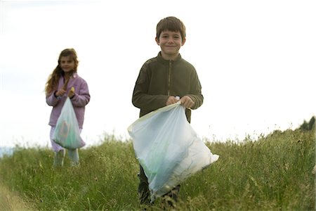 Children picking up trash in field Stock Photo - Premium Royalty-Free, Code: 632-05760624