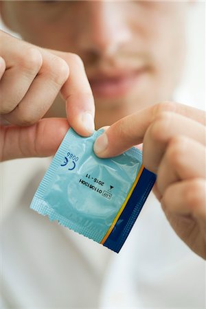 emvelleur - Homme ouvrant emballage du préservatif, recadrée Photographie de stock - Premium Libres de Droits, Code: 632-05760658