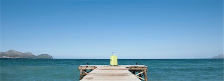 Yellow suitcase at end of dock Foto de stock - Sin royalties Premium, Código: 632-05760674