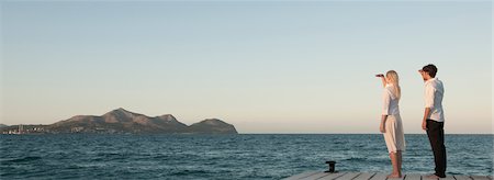 Couple standing on pier looking at view Stock Photo - Premium Royalty-Free, Code: 632-05760731