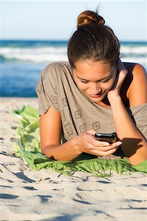 simsearch:632-05817102,k - Woman text messaging on beach Foto de stock - Sin royalties Premium, Código: 632-05816104