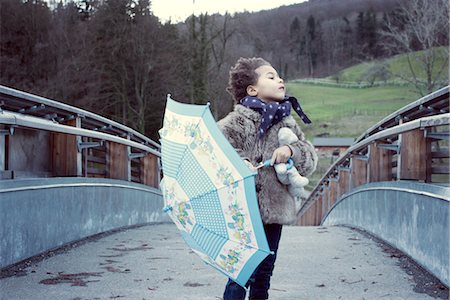 Little girl walking on bridge with umbrella, looking away Stock Photo - Premium Royalty-Free, Code: 632-05816102