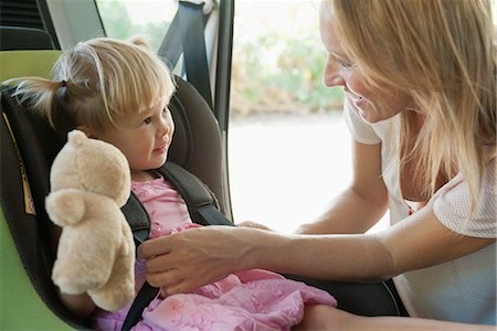 stuffed animal - Mother fastening little girl into car seat Stock Photo - Premium Royalty-Free, Code: 632-05816130