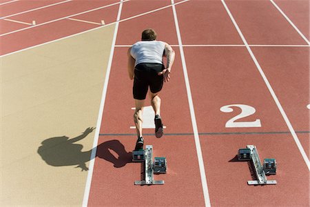 starting block - Runner at starting line, rear view Stock Photo - Premium Royalty-Free, Code: 632-05816197