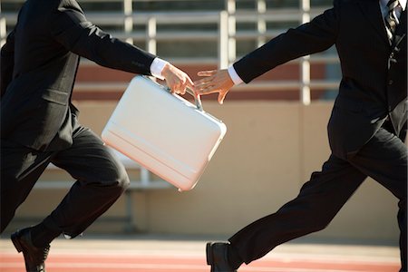 relay race competitions - Businessmen running in relay race, handing off briefcase Stock Photo - Premium Royalty-Free, Code: 632-05816260