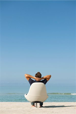 relax man beach one person - Man sitting in armchair on beach looking at ocean, rear view Stock Photo - Premium Royalty-Free, Code: 632-05816277