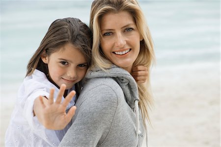 elementary age 2012 - Mother carrying daughter, daughter doing stop gesture at camera, portrait Stock Photo - Premium Royalty-Free, Code: 632-05816314