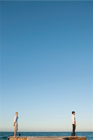 separado - Couple standing back to back on pier, side view Foto de stock - Sin royalties Premium, Código: 632-05816343