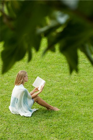 simsearch:632-05400916,k - Young woman sitting on grass reading book, high angle view Foto de stock - Royalty Free Premium, Número: 632-05816376