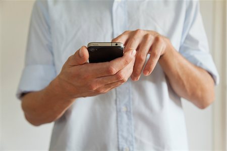 Man holding cell phone, cropped Stock Photo - Premium Royalty-Free, Code: 632-05816455