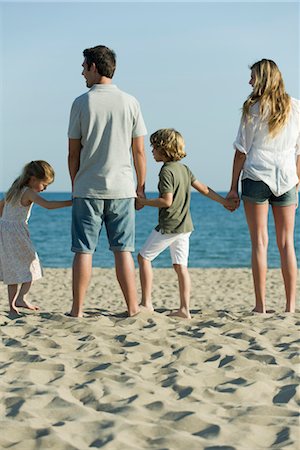 family standing back rear view - Family holding hands at the beach Stock Photo - Premium Royalty-Free, Code: 632-05816499