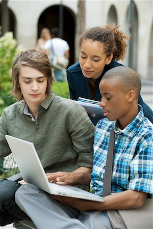 Étudiants discutant devoirs sur le campus avec ordinateur portable Photographie de stock - Premium Libres de Droits, Code: 632-05816577