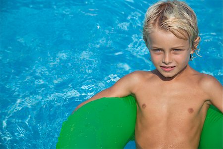 relaxing on innertube - Boy relaxing on float in pool Stock Photo - Premium Royalty-Free, Code: 632-05816578