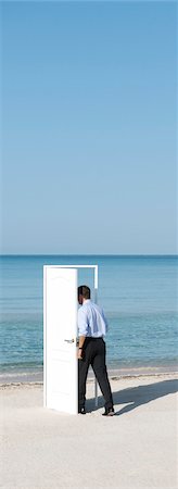 side pose - Man entering open door on beach, rear view Stock Photo - Premium Royalty-Free, Code: 632-05816586