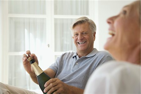 simsearch:632-05816053,k - Couple relaxing together, man opening bottle of champagne Foto de stock - Sin royalties Premium, Código: 632-05816661