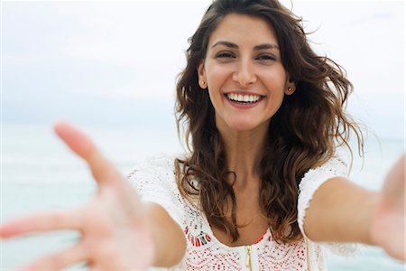 Woman reaching arms toward camera, smiling Stock Photo - Premium Royalty-Free, Code: 632-05816673