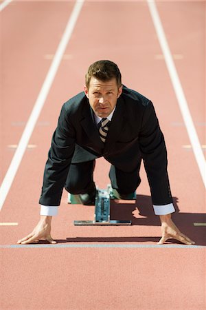 Businessman crouching at starting line on running track Foto de stock - Sin royalties Premium, Código: 632-05816768