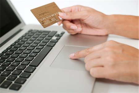 Woman holding credit card while using laptop computer, cropped Stock Photo - Premium Royalty-Free, Code: 632-05816784