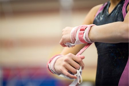 Gymnaste féminine enveloppant les poignets en préparation, recadrée Photographie de stock - Premium Libres de Droits, Code: 632-05816786