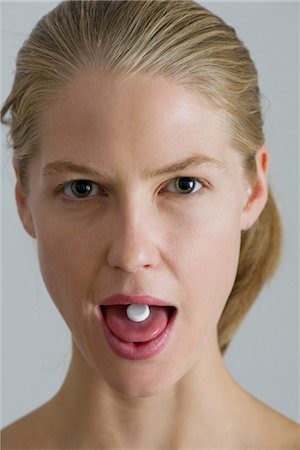 sacando la lengua - Vitamin pill on young woman's tongue Foto de stock - Sin royalties Premium, Código: 632-05816783