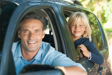 Boy riding in car with father, leaning out window and smiling at camera Stock Photo - Premium Royalty-Free, Code: 632-05816793