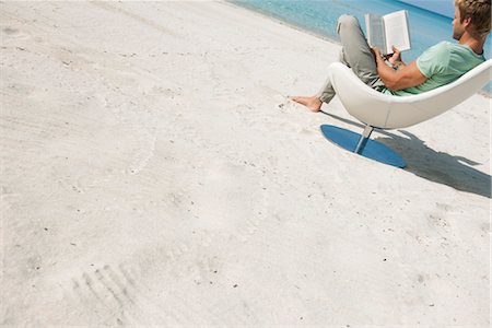 simsearch:632-05816128,k - Young man reading book on beach, tilt Foto de stock - Sin royalties Premium, Código: 632-05816828