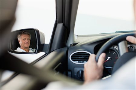 person in car interior - Man driving car, reflected in driver's side mirror Stock Photo - Premium Royalty-Free, Code: 632-05816895