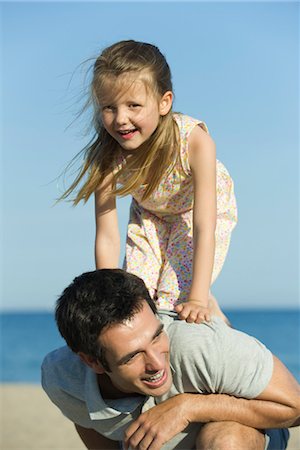 piggyback daughter at beach - Little girl balancing on her father's back Stock Photo - Premium Royalty-Free, Code: 632-05816896