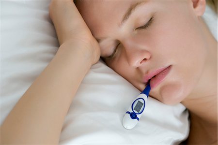 pillow - Young woman checking temperature with thermometer Stock Photo - Premium Royalty-Free, Code: 632-05816949