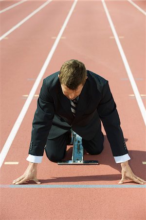 Businessman crouching at starting line on running track Foto de stock - Sin royalties Premium, Código: 632-05816964