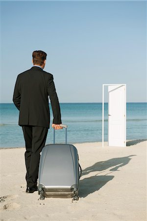 simsearch:632-05817063,k - Businessman pulling suitcase on beach, half-open door in background Stock Photo - Premium Royalty-Free, Code: 632-05816961