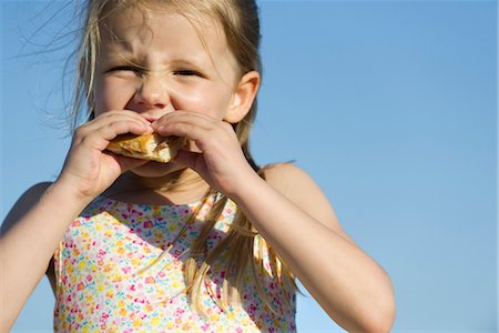 Girl eating sandwich outdoors Stock Photo - Premium Royalty-Free, Code: 632-05816971