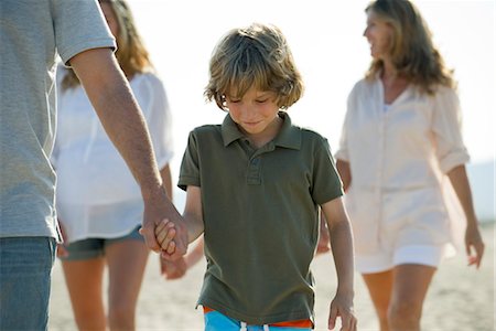 simsearch:632-06318053,k - Boy walking on beach with family, holding father's hand Foto de stock - Sin royalties Premium, Código: 632-05817085