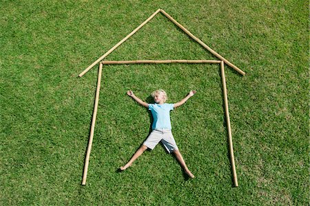 full length - Boy lying on grass within outline of house, high angle view Stock Photo - Premium Royalty-Free, Code: 632-05817109