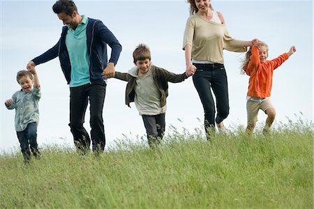 Family running hand in hand in field Stock Photo - Premium Royalty-Free, Code: 632-05845036