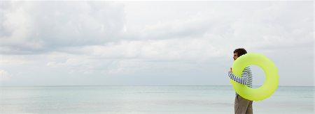 sicherheit - Young man with inflatable ring, looking at ocean Foto de stock - Sin royalties Premium, Código: 632-05845043