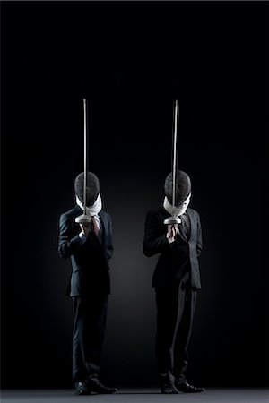 encens - Businessmen with fencing masks holding up fencing foils Stock Photo - Premium Royalty-Free, Code: 632-05845121