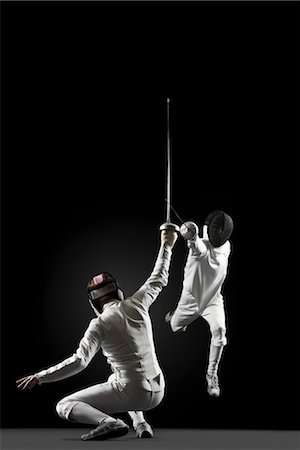 fenced - Fencers fencing, one fencer jumping in air Stock Photo - Premium Royalty-Free, Code: 632-05845181